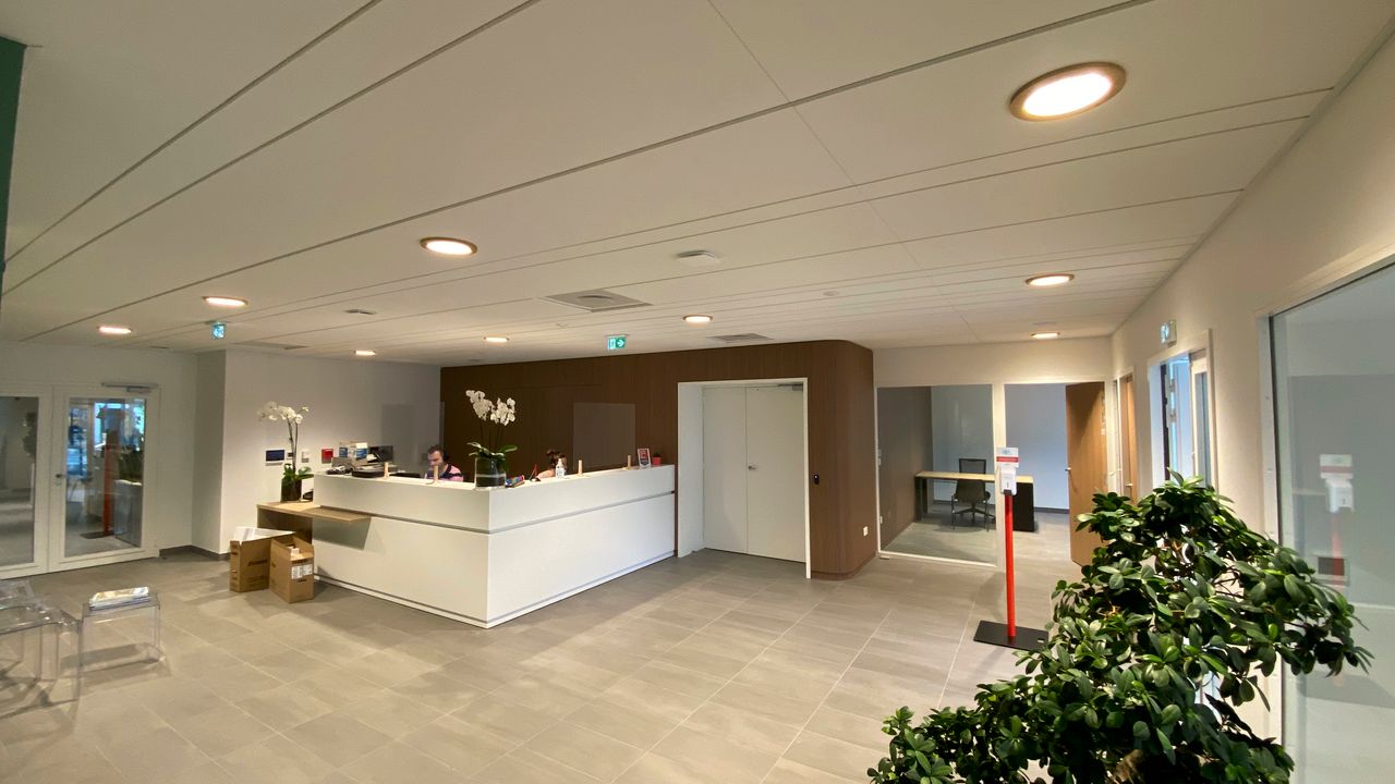Hall d'accueil d'entreprise éclairé par downlights encastrés au plafond