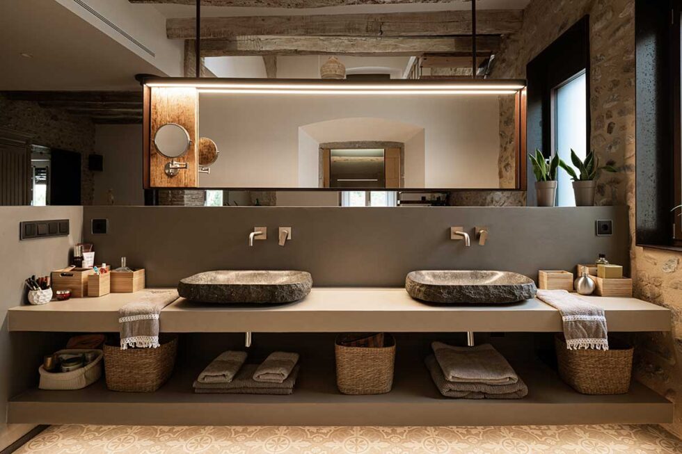 Salle de bains en pierre avec miroir rétroéclairé et double vasque en pierre naturelle